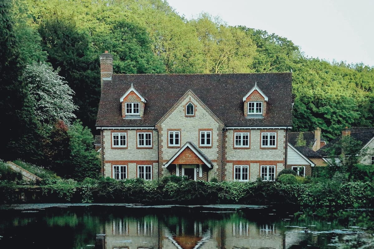 A big house in pristine nature surroundings with a river in front